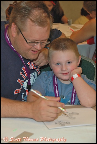 A father helps his son draw Mickey Mouse in the Kid's Room at MagicMeets in Harrisburg, Pennsylvania.
