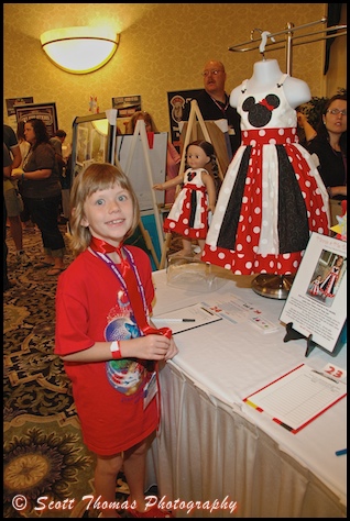 A young MagicMeets attendee admires the Minnie and Me dress set during the Dream Team Auction.